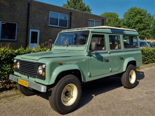 A land rover defender in pastel green with limestone safari roof and Nakatanenga wheels